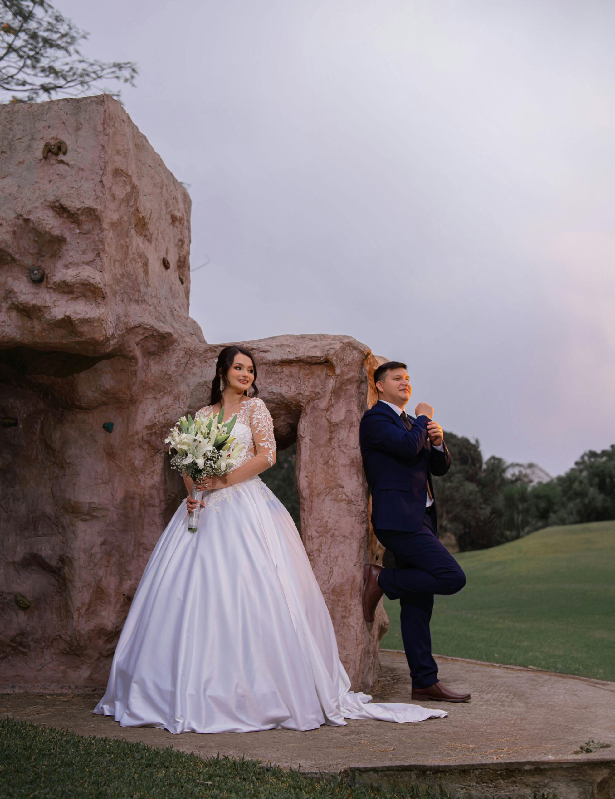 Bride and groom pose elegantly outdoors against a stone backdrop in Santo Domingo.