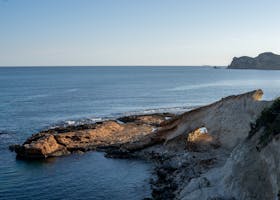 Scenic coastal landscape of Moraira, Spain, with rocky formations and serene blue sea.