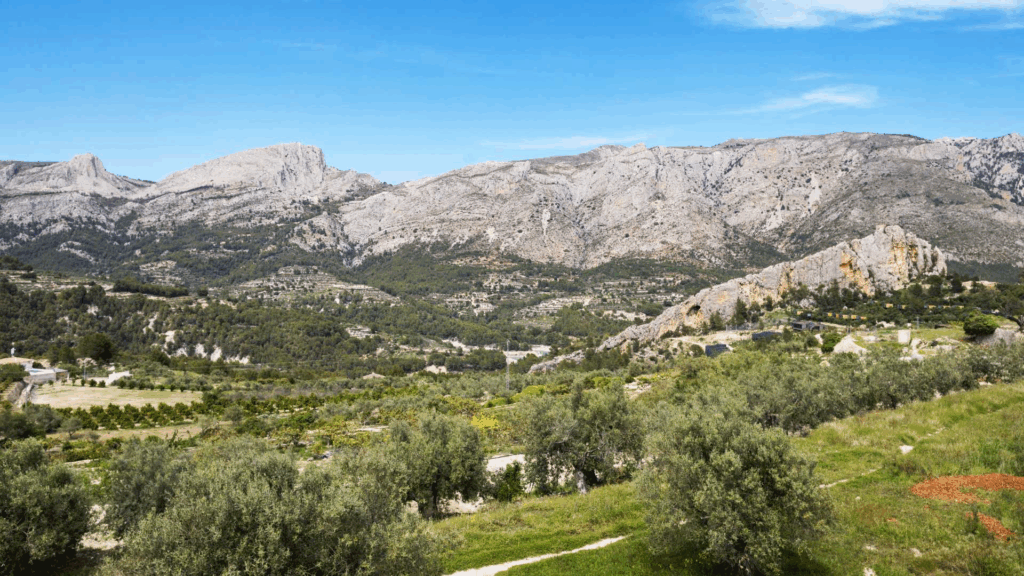 Vista del pueblo de Benimantell rodeado de montañas y almendros en flor en el Valle de Guadalest